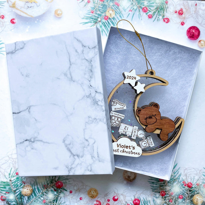 Custom baby's first Christmas ornament with name and birth details in a gift box