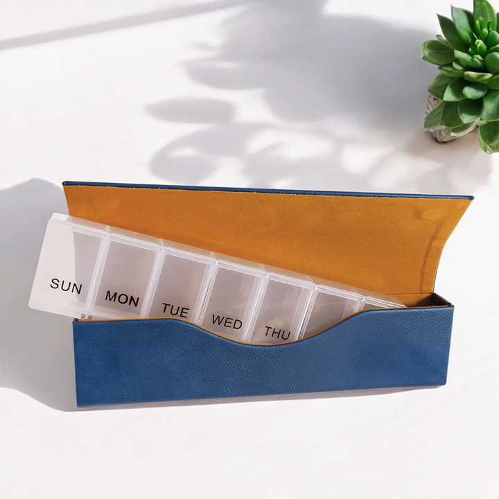 Blue Laserable Leatherette Weekly Pill Box Organizer with seven spacious compartments labeled for each day of the week, featuring a magnetic closure and soft interior lining. Perfect for travel, corporate gifting, or personal medication management.