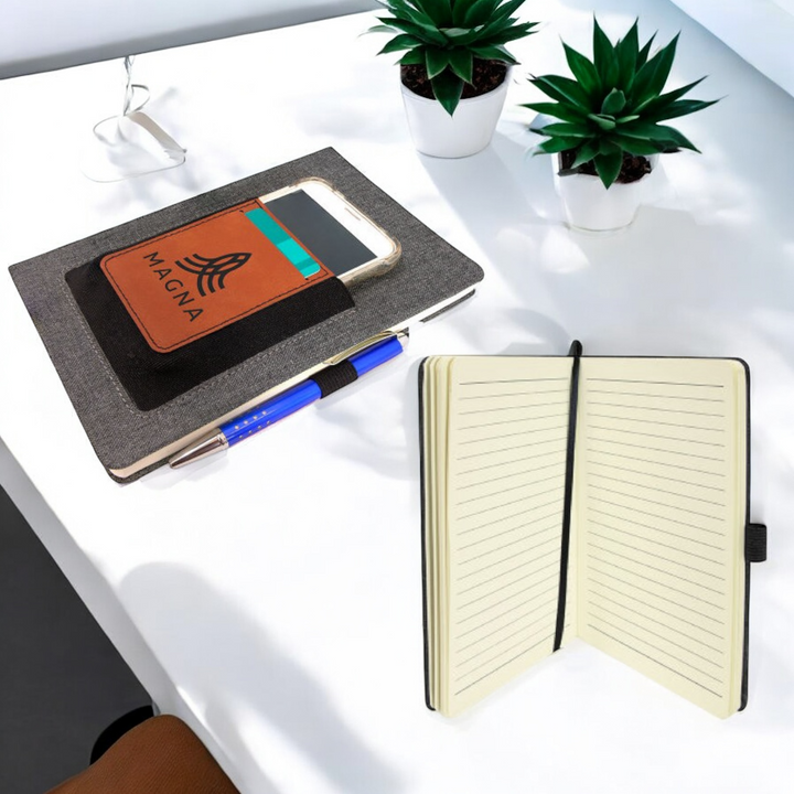 Custom leatherette journal with elastic phone holder, card slot, pen loop, and lined pages, ideal for corporate branding, promotional gifts, and professional use.