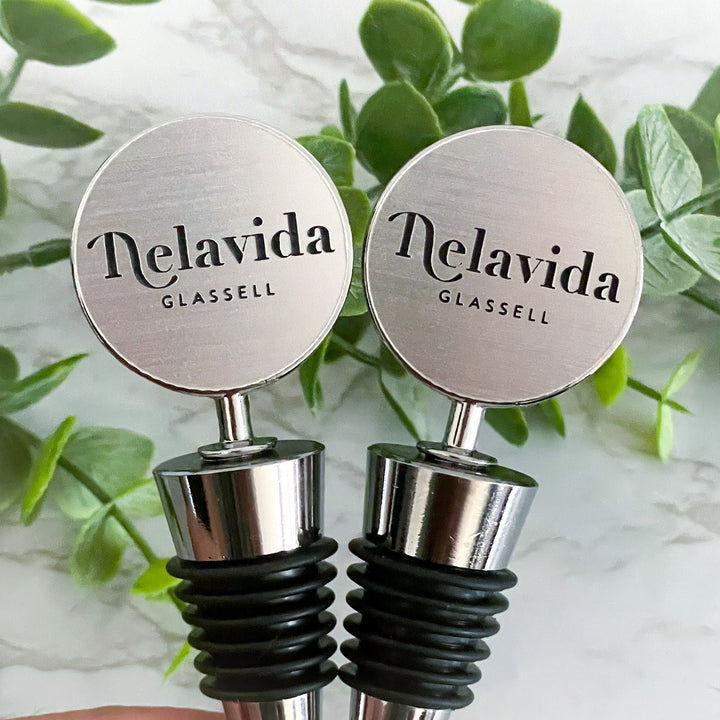 Customized silver wine bottle stoppers featuring the Delavida Glassell logo, ideal for corporate branding, personalized gifts, and elegant promotional items.