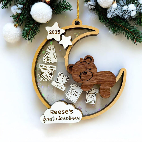 Baby’s first Christmas ornament 2025 for girl featuring engraved wooden bear on crescent moon, personalized with baby's name, unique baby ornament shaker and keepsake gift for new parents.