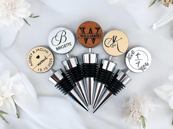 Set of personalized wine stoppers in gold, silver, and wood finishes – customizable names, dates, and text for wedding, engagement, or anniversary gifts.