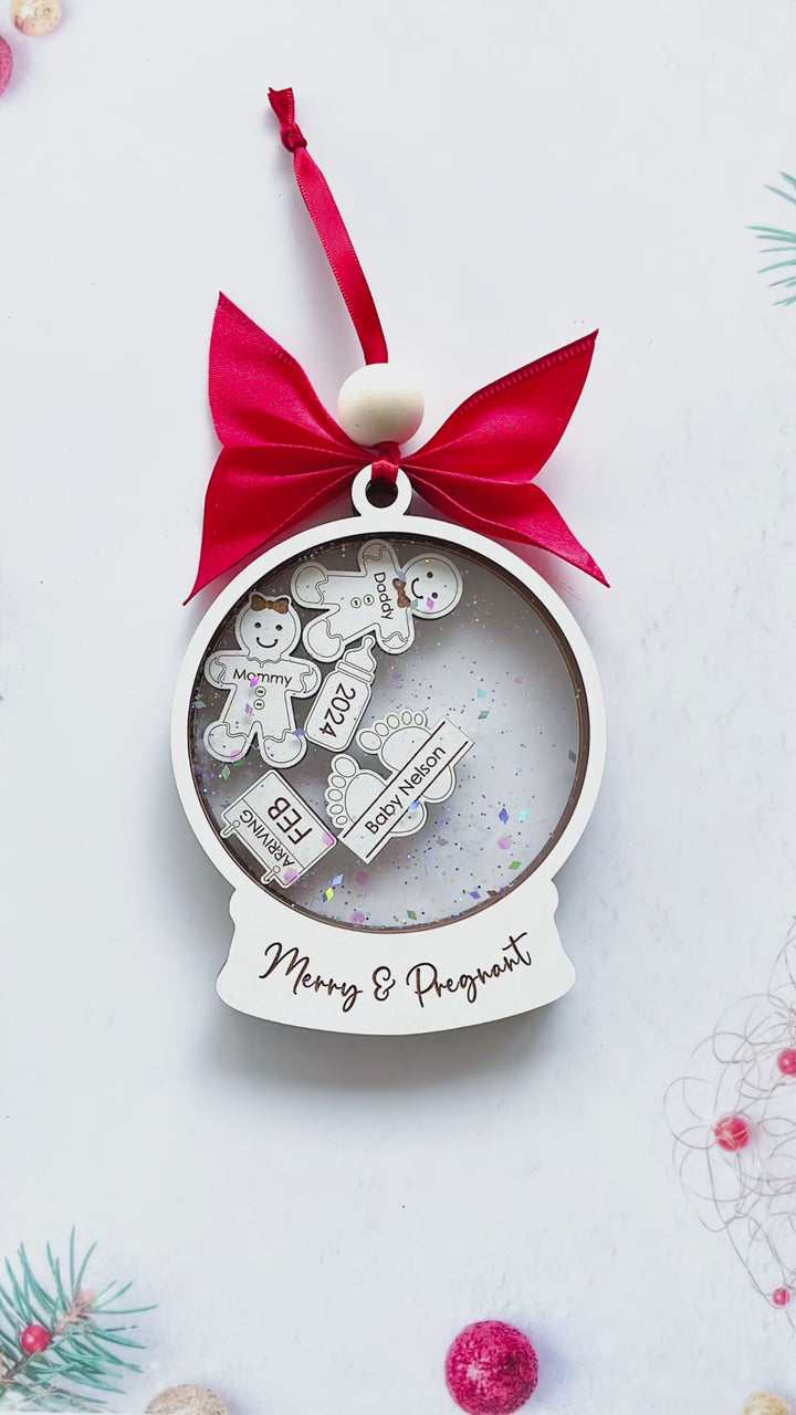 Video of personalized pregnancy announcement ornament for first christmas merry and pregnant