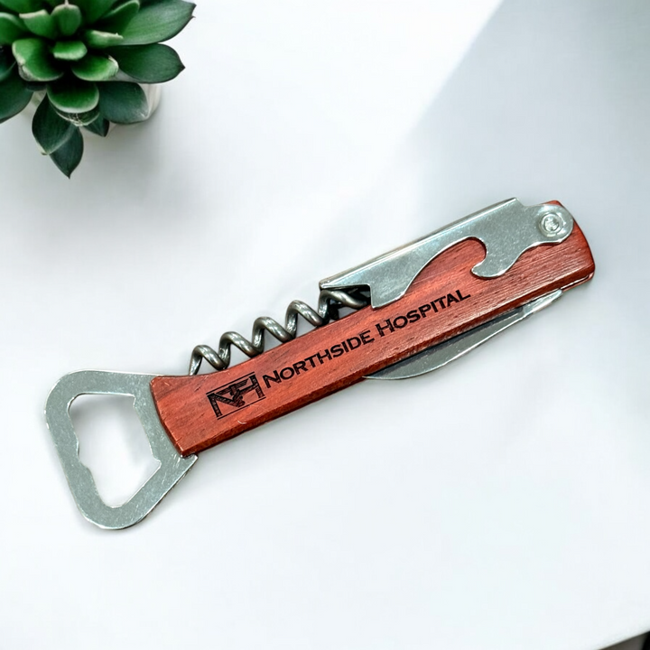 Personalized wooden bottle opener and corkscrew multi-tool featuring the corporate logo, crafted with stainless steel components and a custom-engraved wooden handle, ideal for corporate gifts or promotional branding.